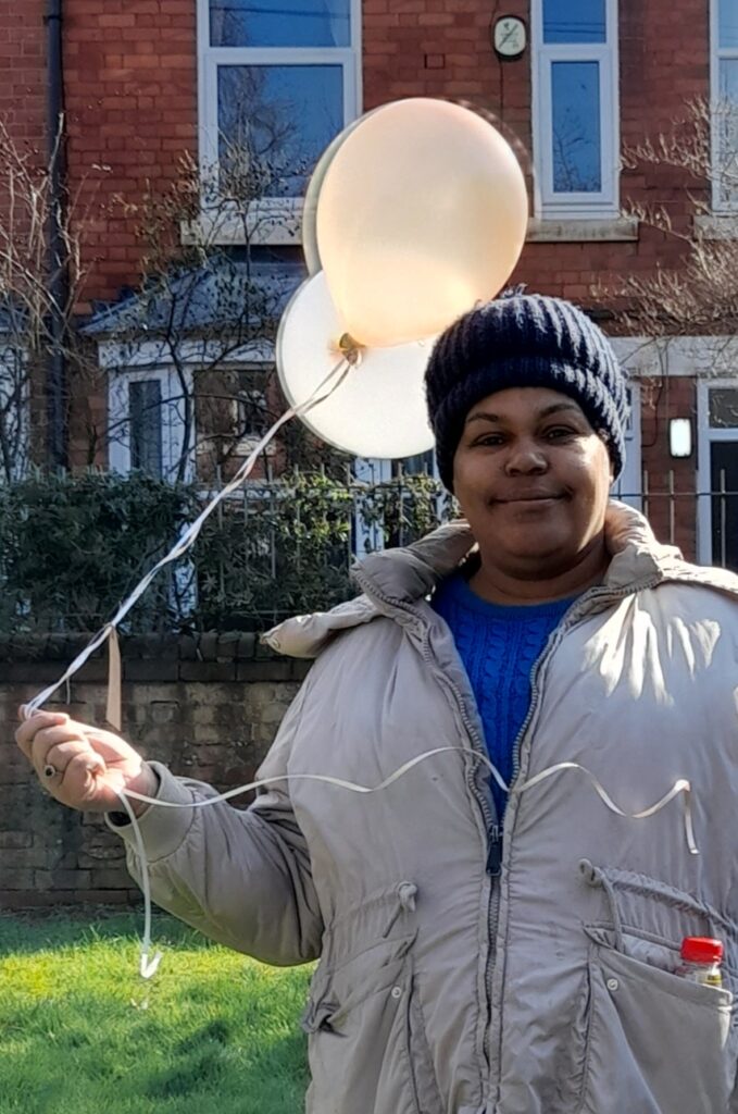Resident holding balloon for The Old Vicarage's first birthday
