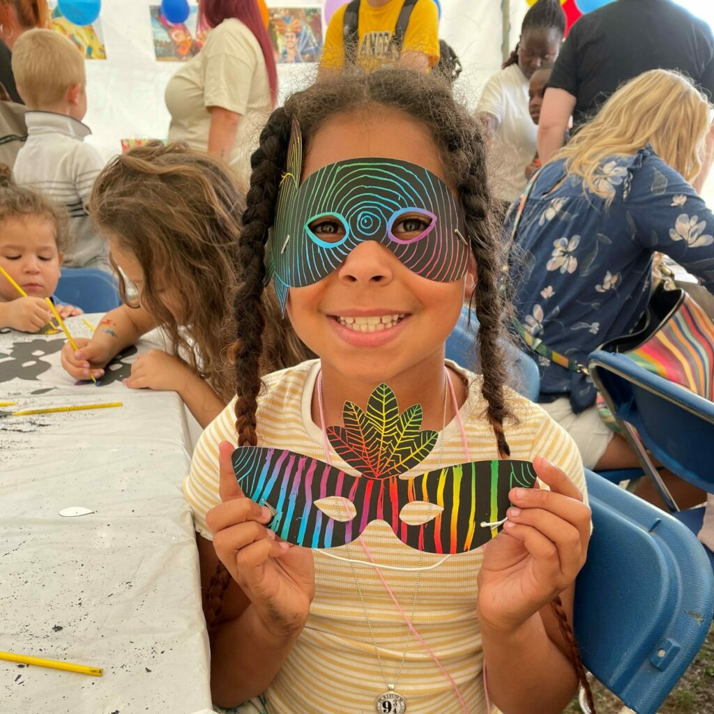 Child doing crafts in Tuntum's Kids Zone at Nottingham Carnival